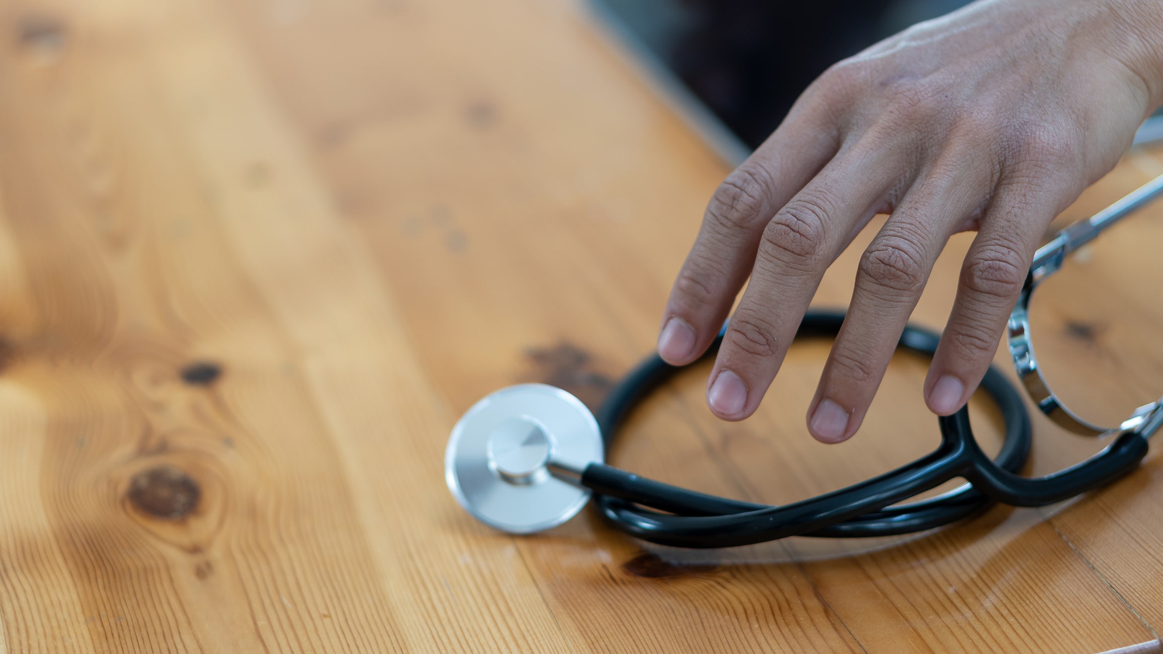 Nurse picking up stethoscope