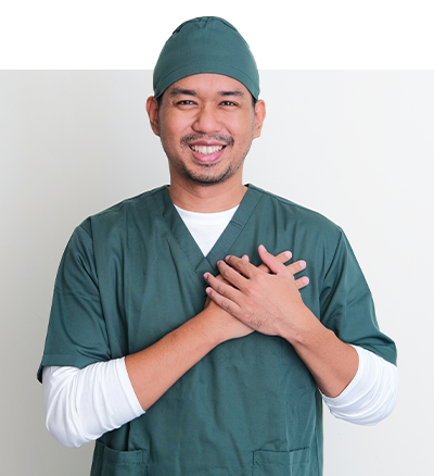 Male surgeon smiling while holding his hands together Male surgeon smiling while holding his hands together