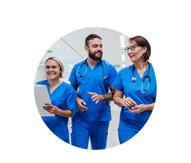 Male nurse speaking with two female nurses in hospital corridor