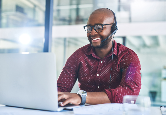 Business man with headset working on laptop