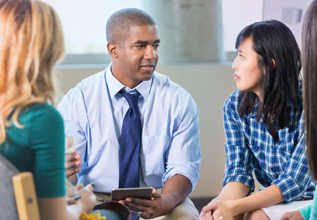 Male behavioral health specialist speaking with group of people
