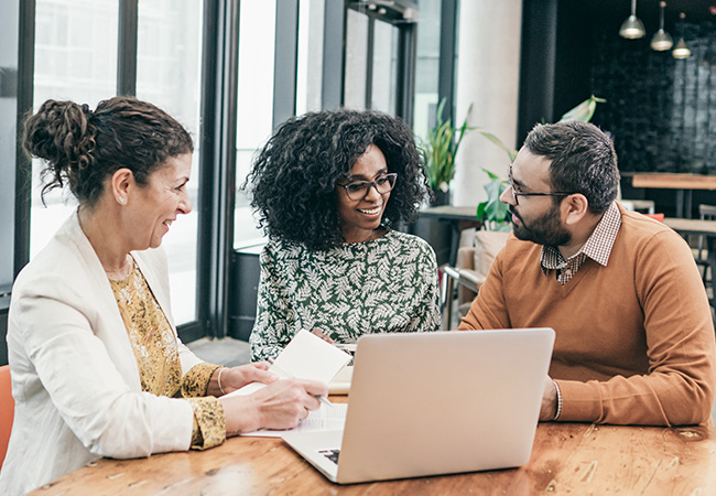 Man and woman talking to female physician at table
