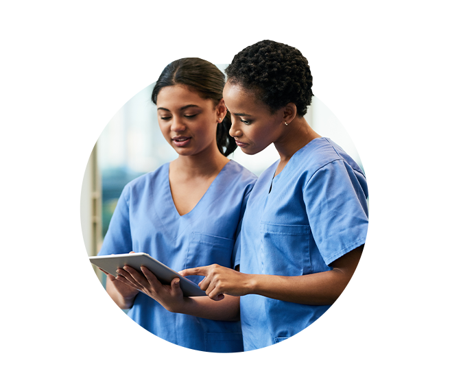 Two female nurses looking at information on tablet computer